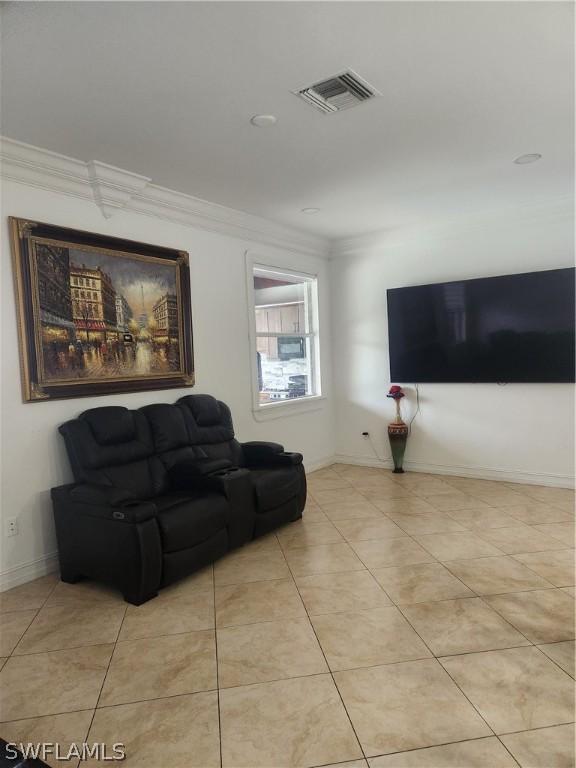 living room with light tile patterned floors and ornamental molding