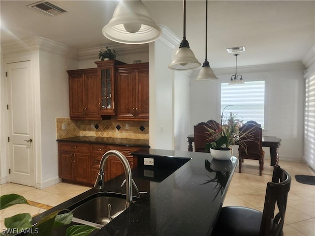 kitchen with sink, ornamental molding, tasteful backsplash, decorative light fixtures, and light tile patterned flooring