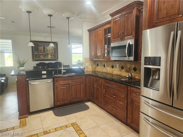 kitchen with appliances with stainless steel finishes, a wealth of natural light, pendant lighting, and sink