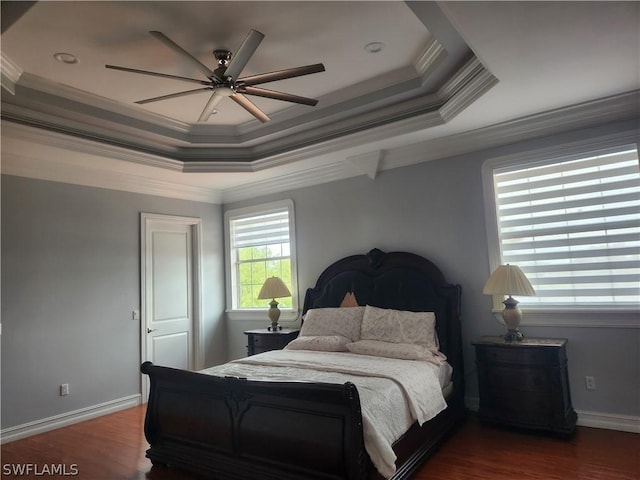 bedroom featuring hardwood / wood-style floors, ceiling fan, a raised ceiling, and ornamental molding