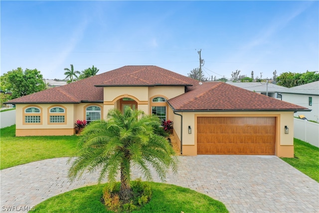 mediterranean / spanish-style house featuring a garage and a front lawn