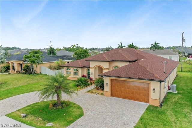 view of front of home with a garage, central AC unit, and a front yard