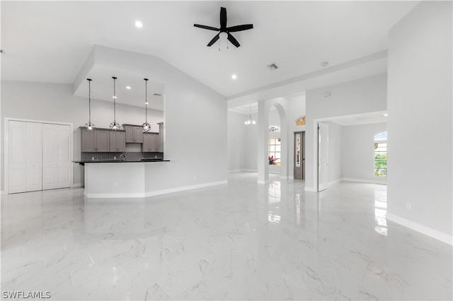 unfurnished living room with lofted ceiling, ceiling fan, and light tile flooring