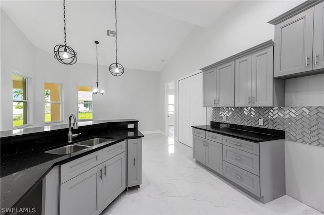 kitchen with gray cabinetry, sink, light tile flooring, and decorative light fixtures