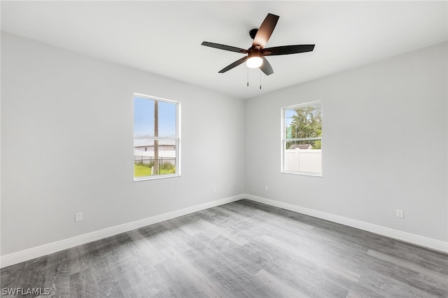 unfurnished room with ceiling fan, a healthy amount of sunlight, and dark hardwood / wood-style floors