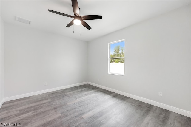 unfurnished room featuring ceiling fan and dark wood-type flooring