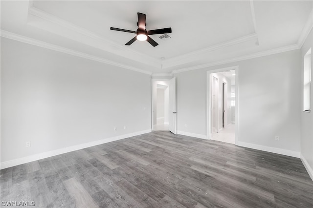 unfurnished room with ornamental molding, ceiling fan, dark hardwood / wood-style floors, and a tray ceiling