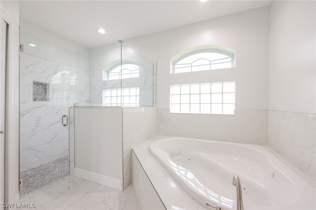 bathroom with a wealth of natural light, independent shower and bath, and tile flooring