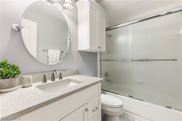 full bathroom featuring tile floors, combined bath / shower with glass door, toilet, and oversized vanity