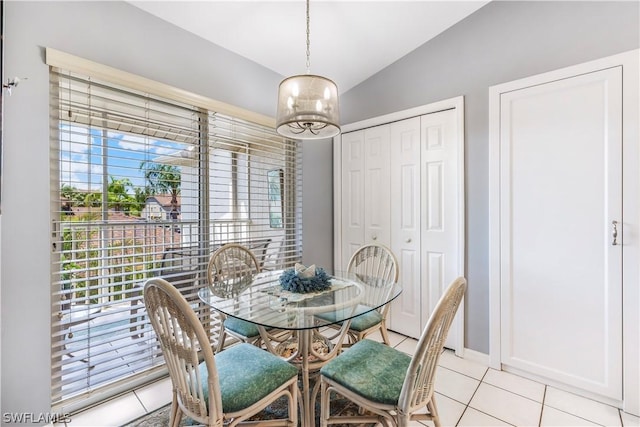 dining room with lofted ceiling, light tile patterned floors, and a notable chandelier