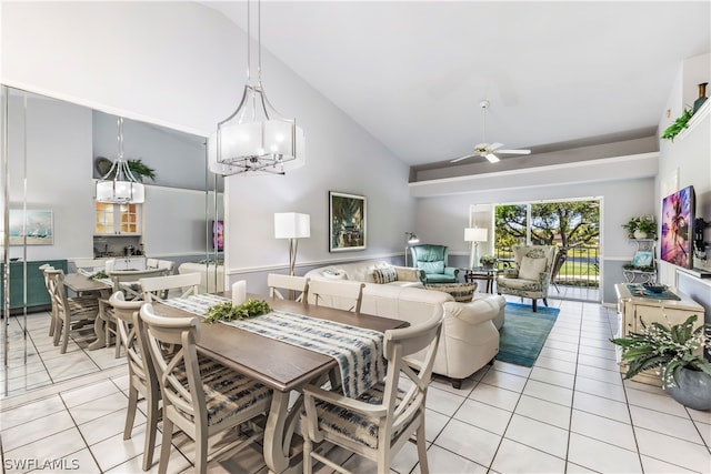 dining room featuring ceiling fan with notable chandelier, high vaulted ceiling, and light tile flooring