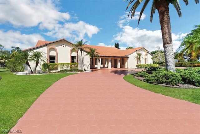 mediterranean / spanish-style house featuring a front lawn