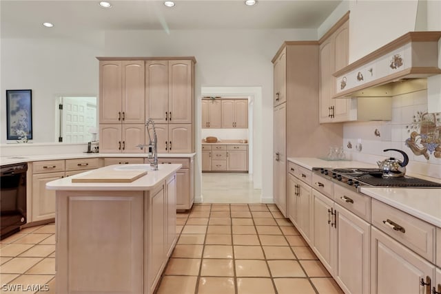 kitchen featuring sink, a kitchen island with sink, black dishwasher, and light tile patterned flooring