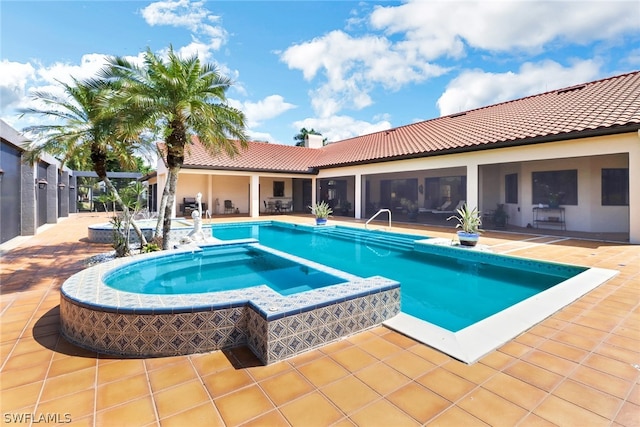 view of pool with a patio area and an in ground hot tub