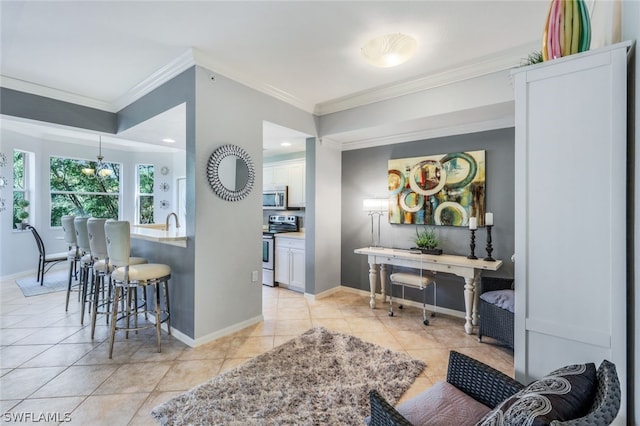 interior space featuring light tile patterned flooring, appliances with stainless steel finishes, a breakfast bar area, white cabinets, and ornamental molding