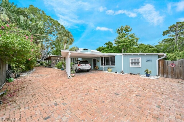 view of front of property featuring fence and a carport