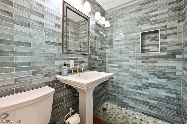 bathroom with tasteful backsplash, tile walls, and toilet