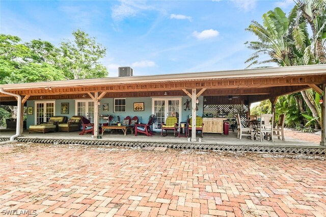 exterior space with central AC unit, french doors, and outdoor lounge area