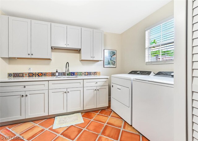 laundry room featuring washing machine and dryer, light tile patterned flooring, a sink, and cabinet space