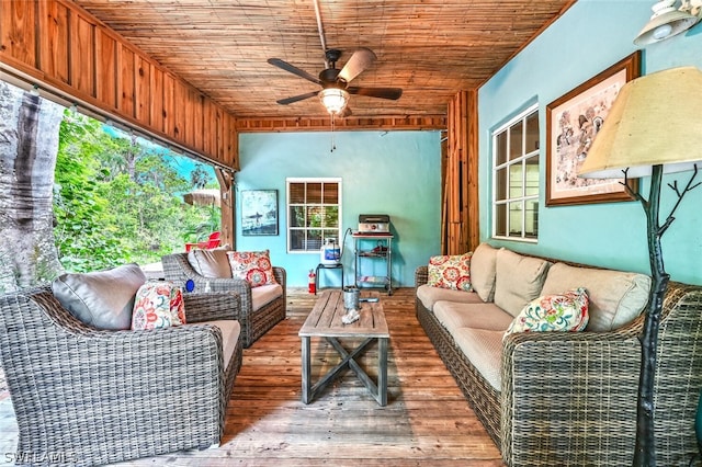 sunroom with a ceiling fan and wooden ceiling