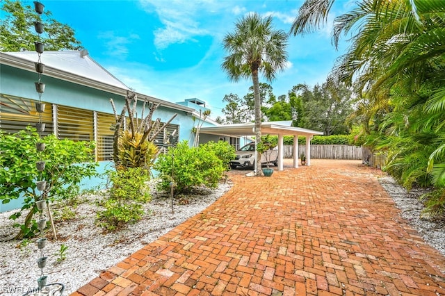 view of patio with a carport and fence