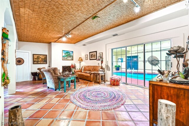 tiled living area with rail lighting and visible vents