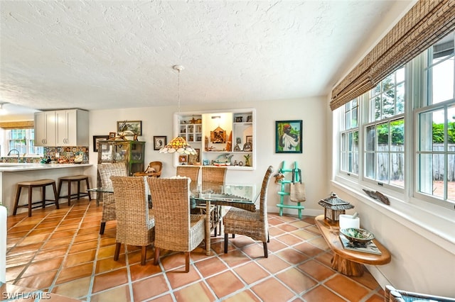 dining area with light tile patterned floors and a textured ceiling