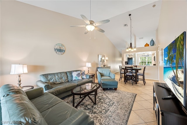 tiled living room featuring ceiling fan with notable chandelier and high vaulted ceiling