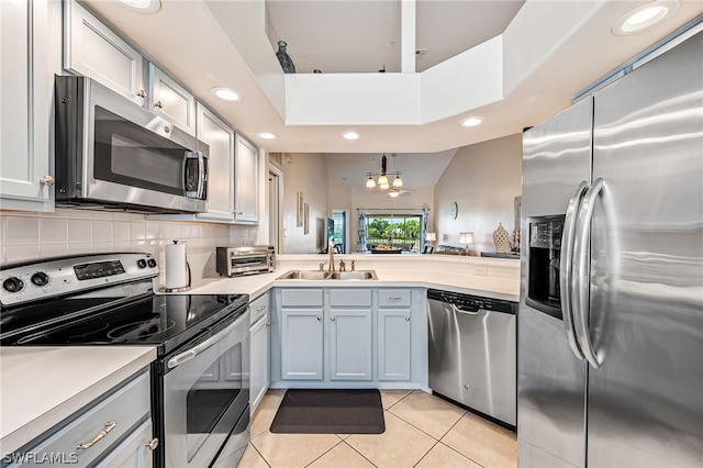 kitchen featuring high vaulted ceiling, light tile flooring, backsplash, stainless steel appliances, and sink