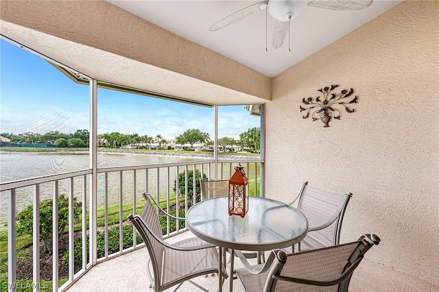 balcony featuring a water view and ceiling fan