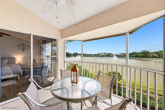 sunroom featuring a water view, ceiling fan, and lofted ceiling