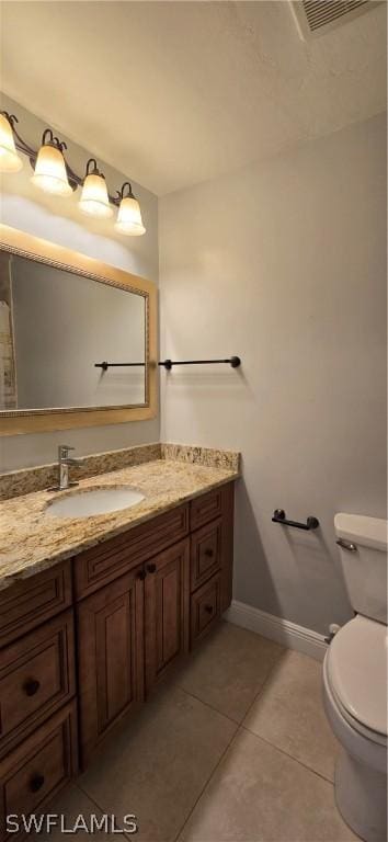 bathroom featuring tile patterned flooring, vanity, and toilet