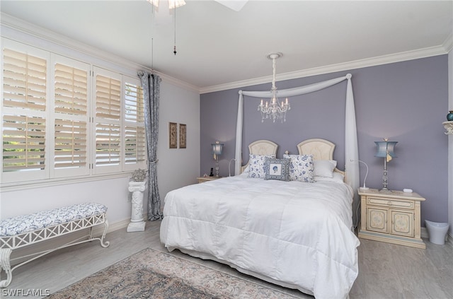 bedroom featuring ornamental molding, ceiling fan with notable chandelier, and light wood-type flooring