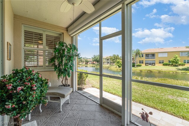 unfurnished sunroom with a water view and ceiling fan