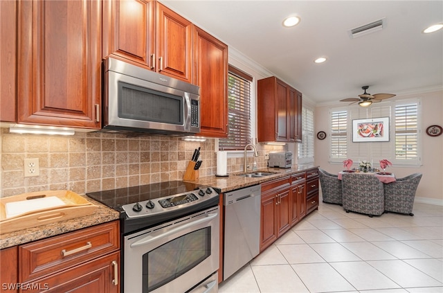 kitchen with stainless steel appliances, light tile floors, light stone counters, tasteful backsplash, and ceiling fan