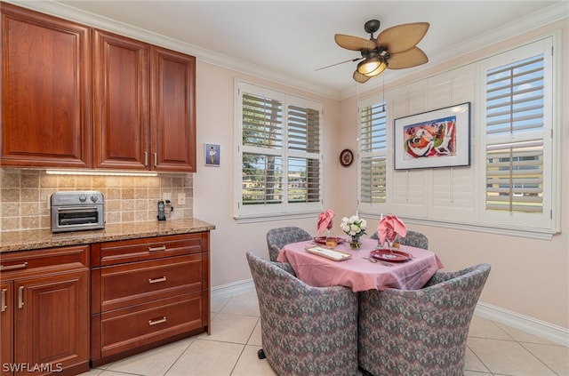 dining room with ceiling fan, light tile flooring, and ornamental molding