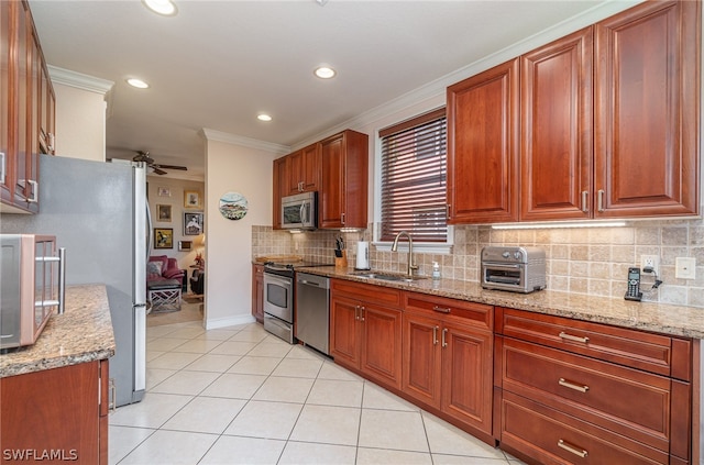 kitchen featuring backsplash, appliances with stainless steel finishes, sink, light stone counters, and ceiling fan