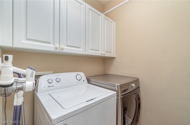 laundry area with washing machine and dryer and cabinets