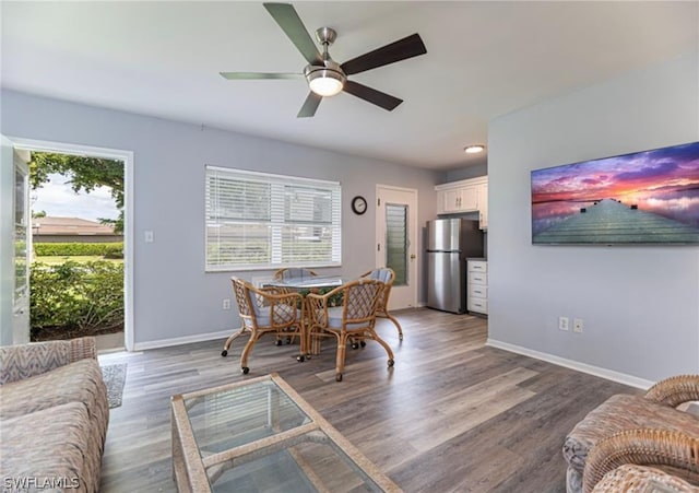 living room featuring ceiling fan and dark hardwood / wood-style flooring