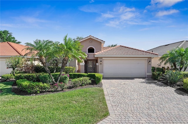 mediterranean / spanish-style home featuring a garage and a front yard