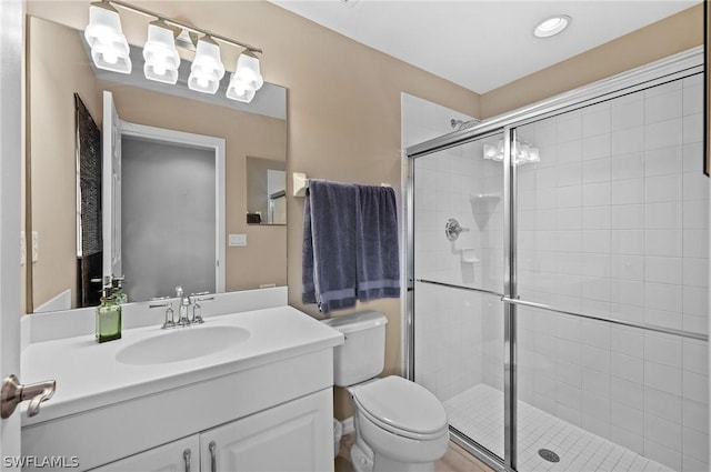 bathroom with vanity, an enclosed shower, and toilet