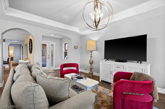 living room featuring a raised ceiling, ornamental molding, and an inviting chandelier