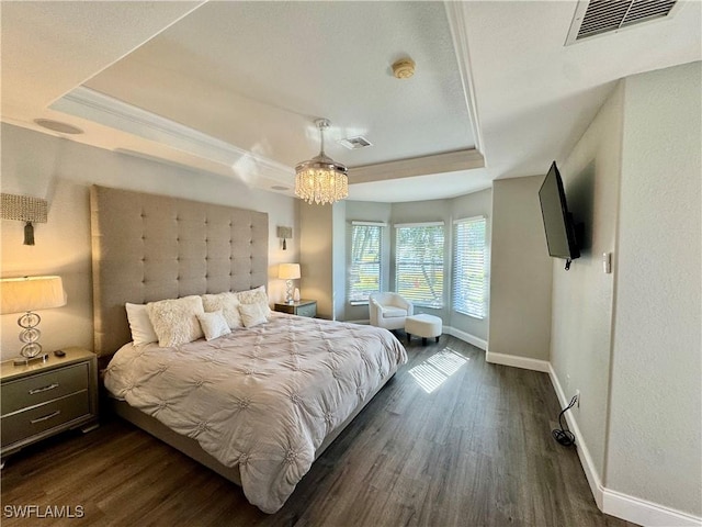 bedroom featuring a raised ceiling, dark wood-type flooring, and crown molding