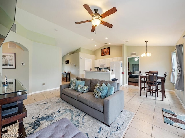 tiled living room featuring ceiling fan with notable chandelier and vaulted ceiling