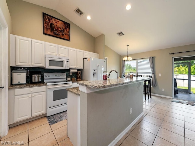 kitchen with white cabinets, white appliances, backsplash, an island with sink, and pendant lighting