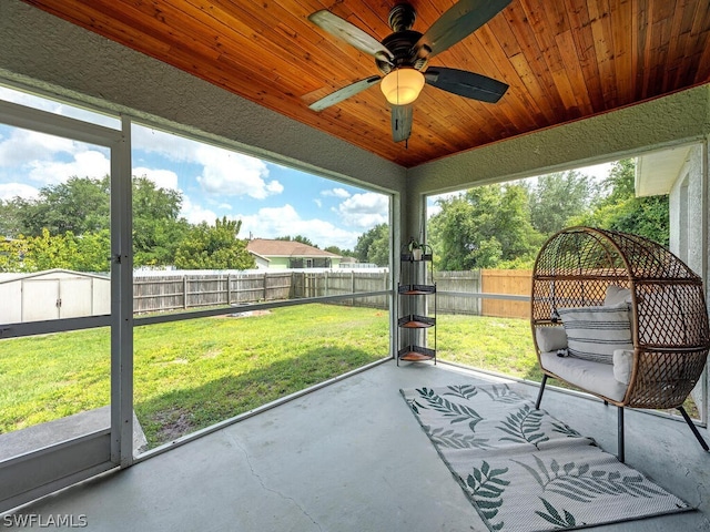 unfurnished sunroom with ceiling fan and wooden ceiling