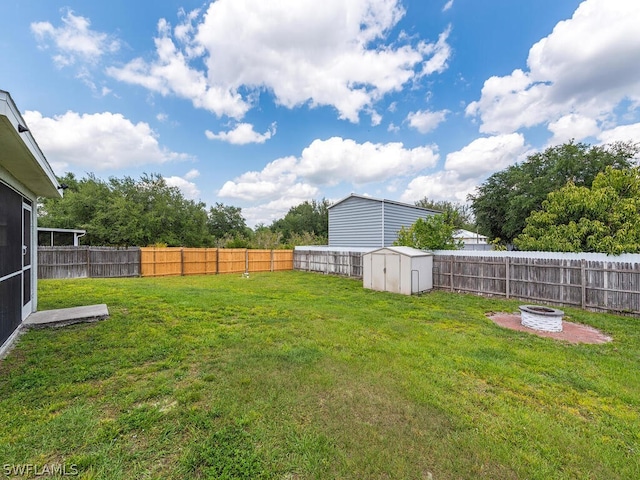 view of yard featuring an outdoor fire pit and a storage unit