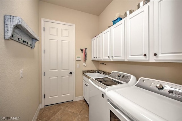 clothes washing area featuring sink, washing machine and dryer, cabinets, and light tile patterned flooring