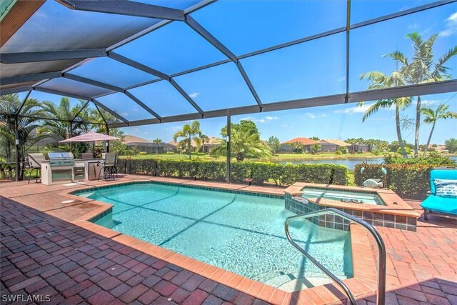 view of pool with an in ground hot tub, a lanai, exterior kitchen, a water view, and a patio