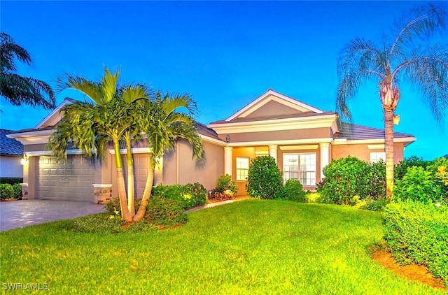 view of front facade with a garage and a lawn